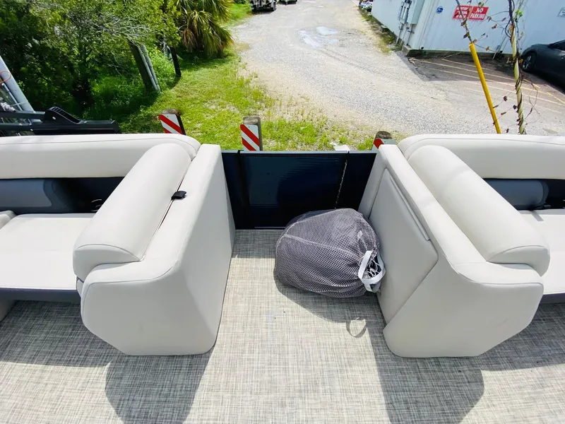 Slide: The Image of 2023 Harris Cruiser 230 boat interior with beige seating and outdoor view. - 10