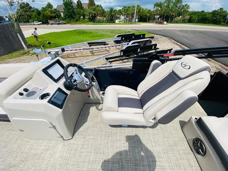 Slide: The Image of 2023 Harris Cruiser 230 boat interior with steering console and plush seating. - 11