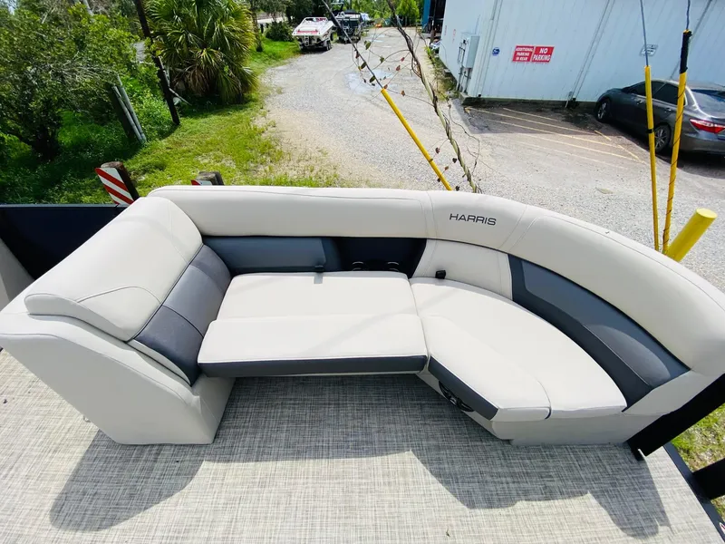 Slide: The Image of 2023 Harris Cruiser 230 boat seating, beige and gray upholstery, outdoor setting. - 7