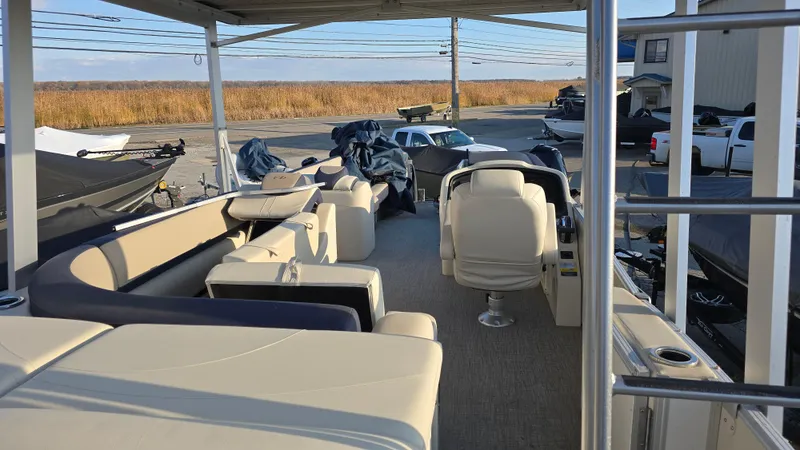 Slide: The Image of 2023 Avalon Catalina Cruise Funship boat interior with seating and helm, parked outdoors. - 9