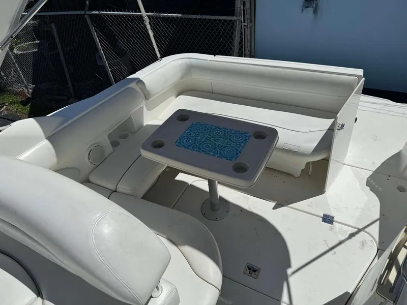 Slide: The Image of 2002 Larson 310 Cabrio boat interior with white seating and table. - 10