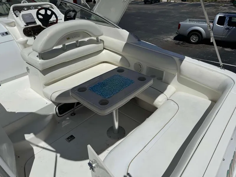 Slide: The Image of 2002 Larson 310 Cabrio boat interior with seating and table. - 11