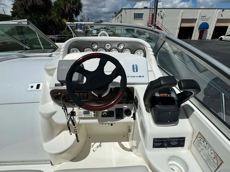 Slide: The Image of 2002 Larson 310 Cabrio boat helm with steering wheel and control panel. - 13