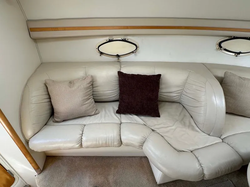 Slide: The Image of 2002 Larson 310 Cabrio interior with plush leather seating and decorative pillows. - 20