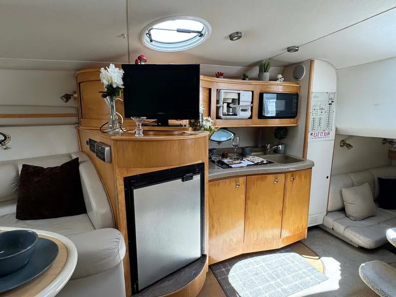 Slide: The Image of Interior of 2002 Larson 310 Cabrio boat with kitchenette and seating area. - 23