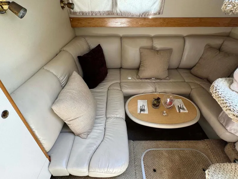 Slide: The Image of Cozy interior of 2002 Larson 310 Cabrio with beige seating and small dining table. - 26
