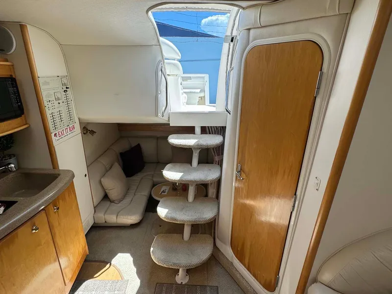 Slide: The Image of Interior of 2002 Larson 310 Cabrio boat with cozy seating and wooden cabinetry. - 28