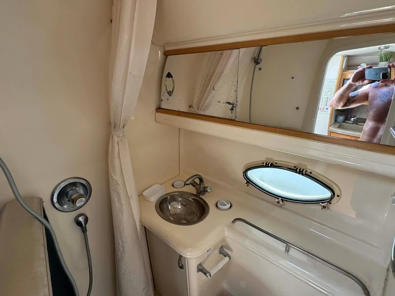 Slide: The Image of 2002 Larson 310 CABRIO boat bathroom with sink, mirror, and porthole window. - 29