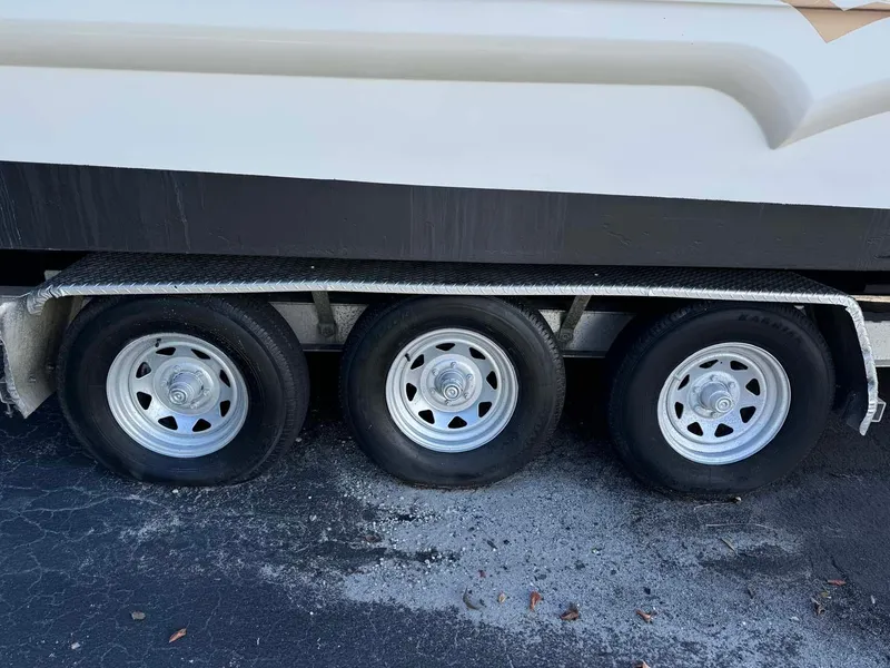 Slide: The Image of Triple-axle trailer for 2002 Larson 310 Cabrio boat on pavement. - 3