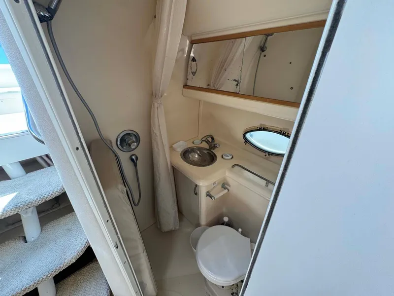 Slide: The Image of 2002 Larson 310 Cabrio boat bathroom with sink, toilet, and shower. - 30