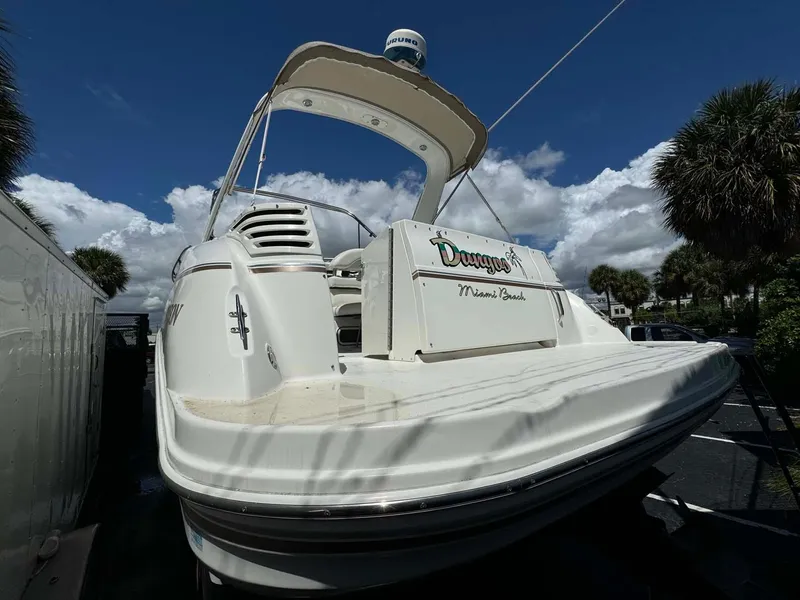 Slide: The Image of 2002 Larson 310 Cabrio boat docked under a clear blue sky. - 7