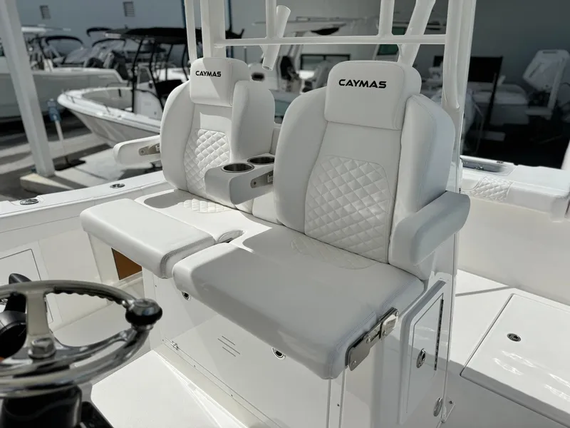 Slide: The Image of 2025 Caymas 30 CT boat with white cushioned seats and steering wheel. - 13