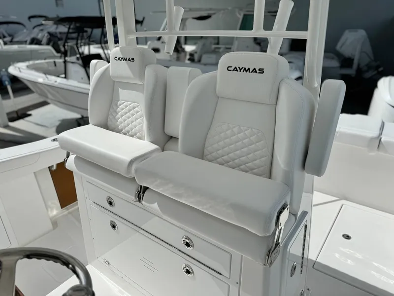 Slide: The Image of 2025 Caymas 30 CT boat with white cushioned seats and storage compartments. - 14