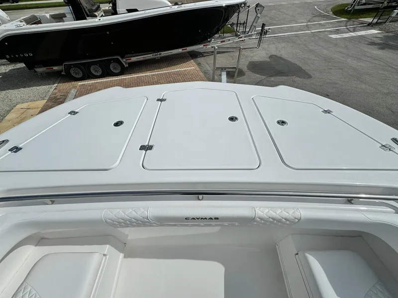 Slide: The Image of 2025 Caymas 30 CT boat deck, white finish, parked near another boat. - 21