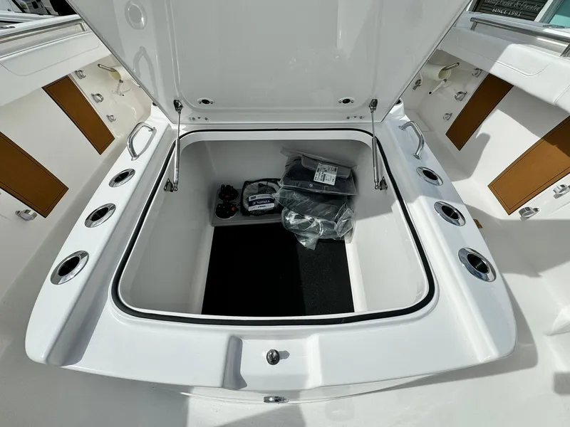 Slide: The Image of 2025 Caymas 30 CT boat storage compartment with open lid and accessories. - 25