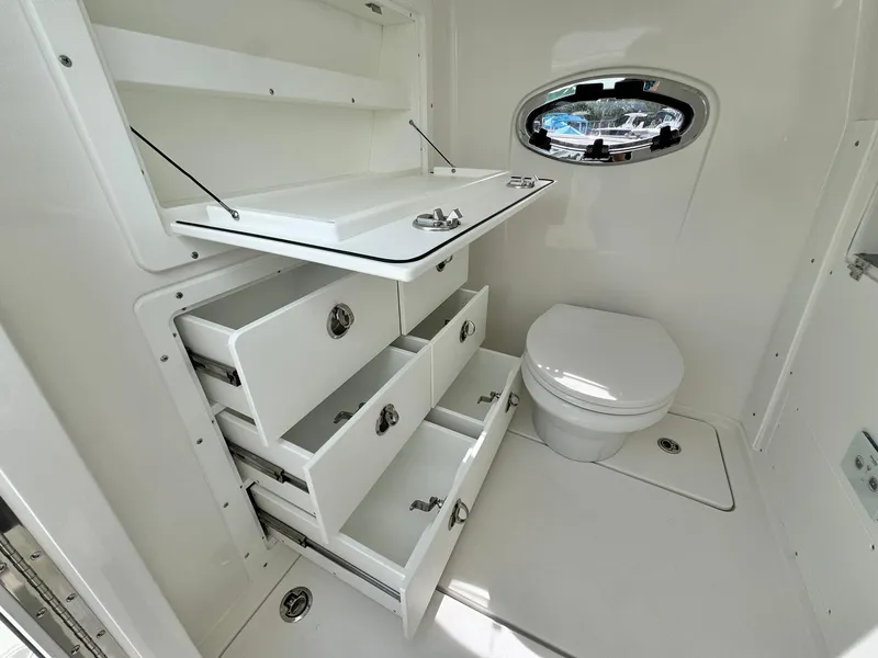 Slide: The Image of 2025 Caymas 30 CT boat bathroom with storage drawers and porthole window. - 28