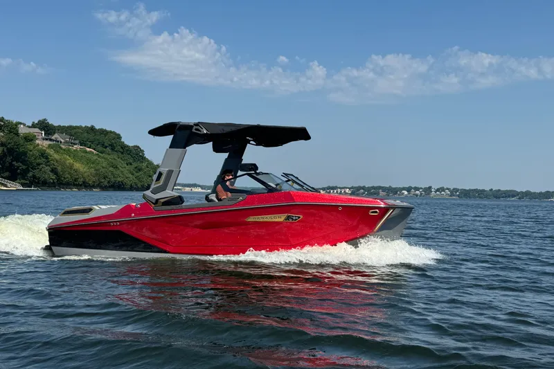 The Image of 2024 Nautique Super Air Nautique G23 Paragon cruising on a lake under a clear sky. - 0