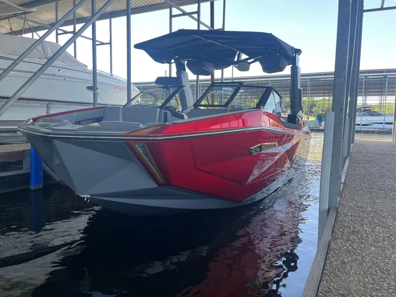 Slide: The Image of 2024 Nautique G23 Paragon boat in dock, vibrant red exterior, sleek design. - 2