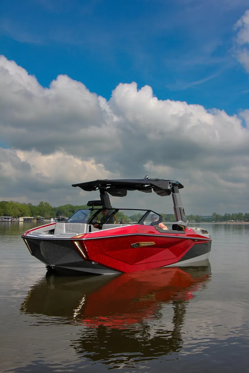 Slide: The Image of 2024 Nautique G23 Paragon boat on calm water under a cloudy sky. - 3