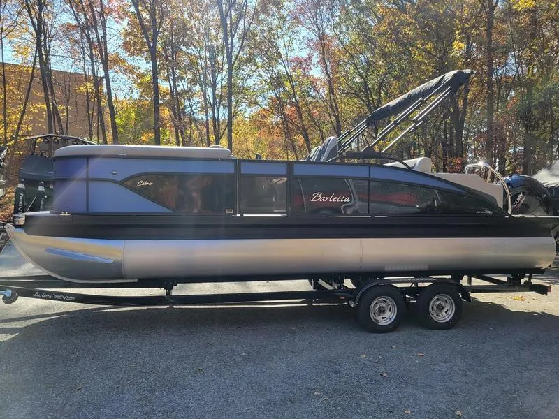 Slide: The Image of 2025 Barletta C22UC pontoon boat on trailer, surrounded by autumn trees. - 3