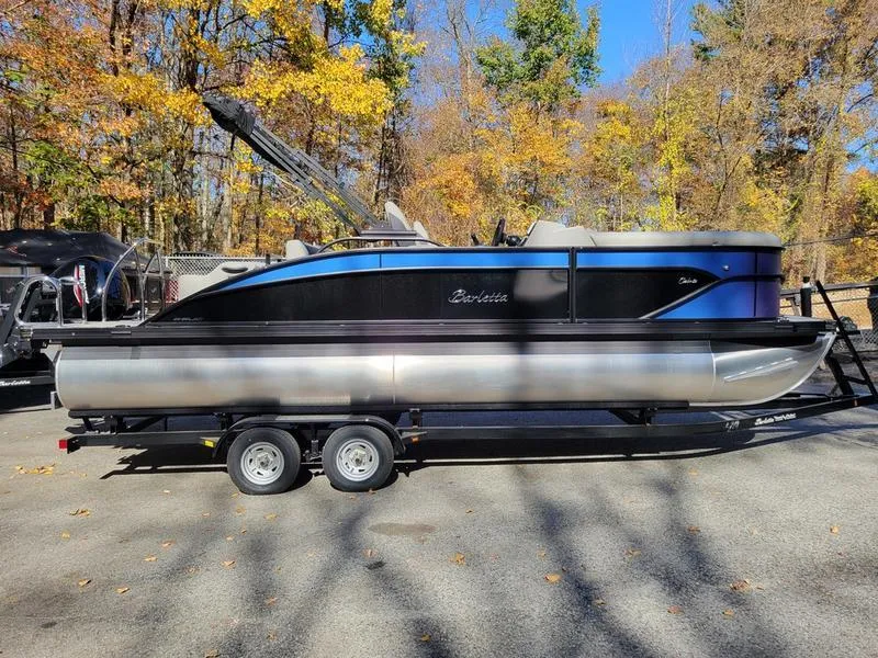 Slide: The Image of 2025 Barletta C22UC pontoon boat on trailer, surrounded by autumn trees. - 7