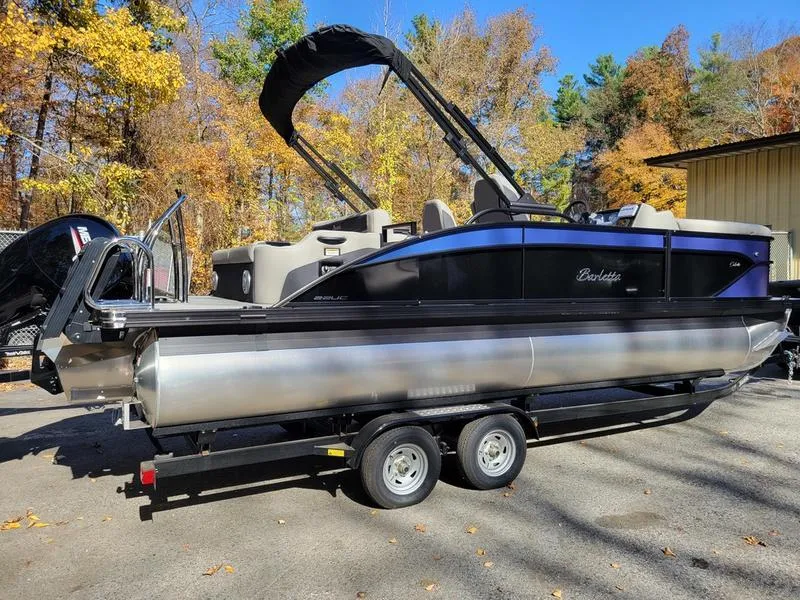 Slide: The Image of 2025 Barletta C22UC pontoon boat on trailer, surrounded by autumn trees. - 9
