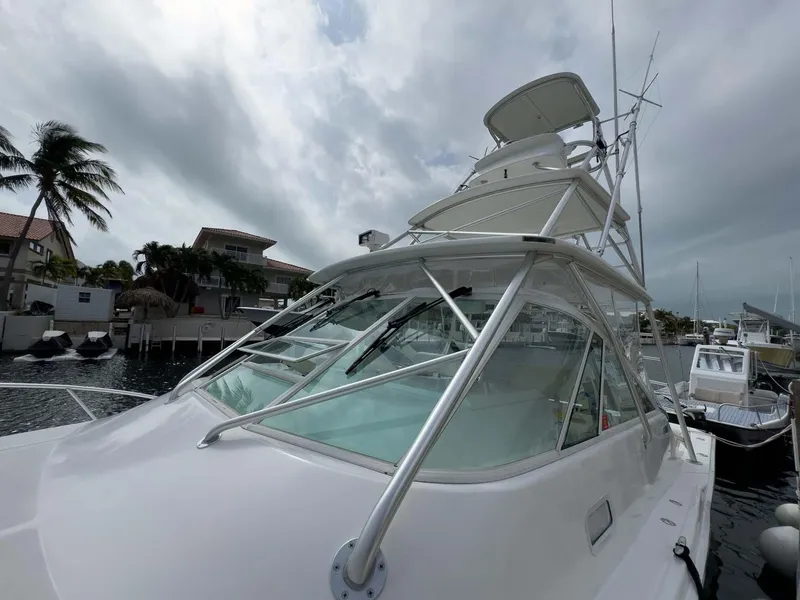 Slide: The Image of 2007 Cabo 35 Express boat docked near palm trees under cloudy sky. - 11