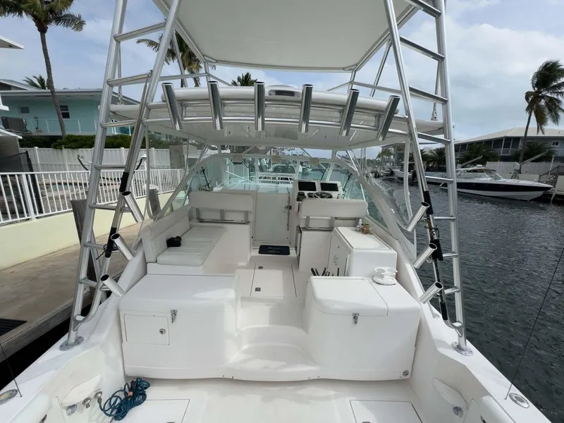 Slide: The Image of 2007 Cabo 35 Express boat docked, featuring spacious deck and seating area. - 16
