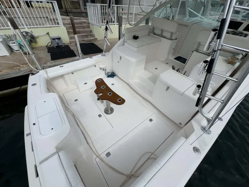 Slide: The Image of 2007 Cabo 35 Express boat deck with seating and fishing rod holders. - 18