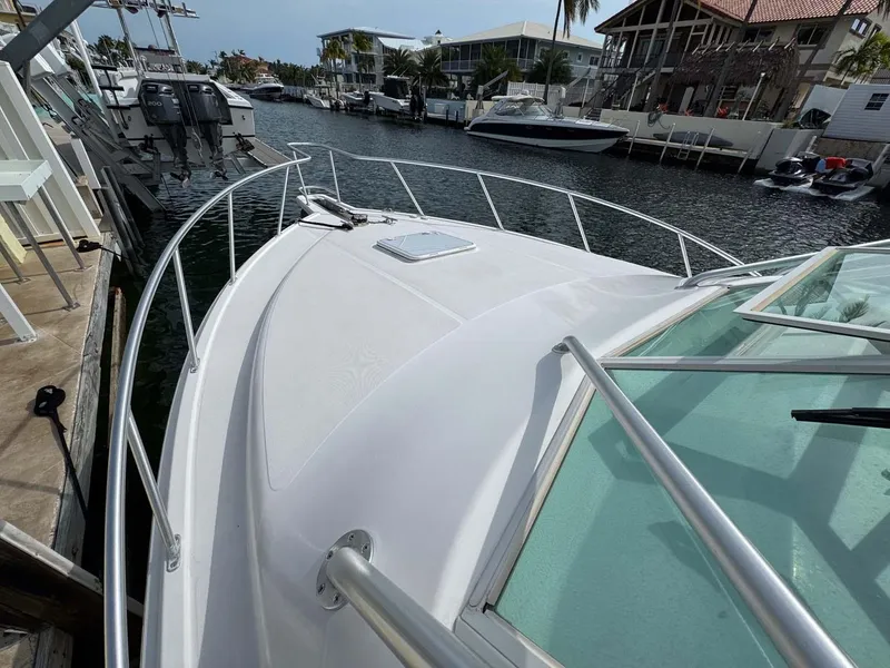Slide: The Image of 2007 Cabo 35 Express boat docked in a marina, featuring sleek design and spacious deck. - 22
