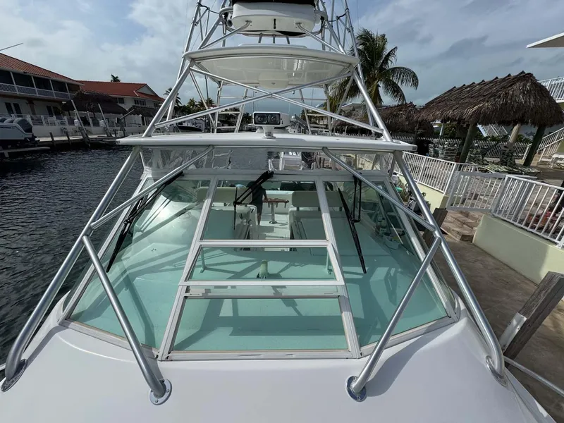 Slide: The Image of 2007 Cabo 35 Express boat docked at marina, featuring spacious deck and tower. - 23