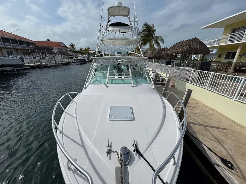 Slide: The Image of 2007 Cabo 35 Express yacht docked in a marina, featuring a sleek white design. - 27