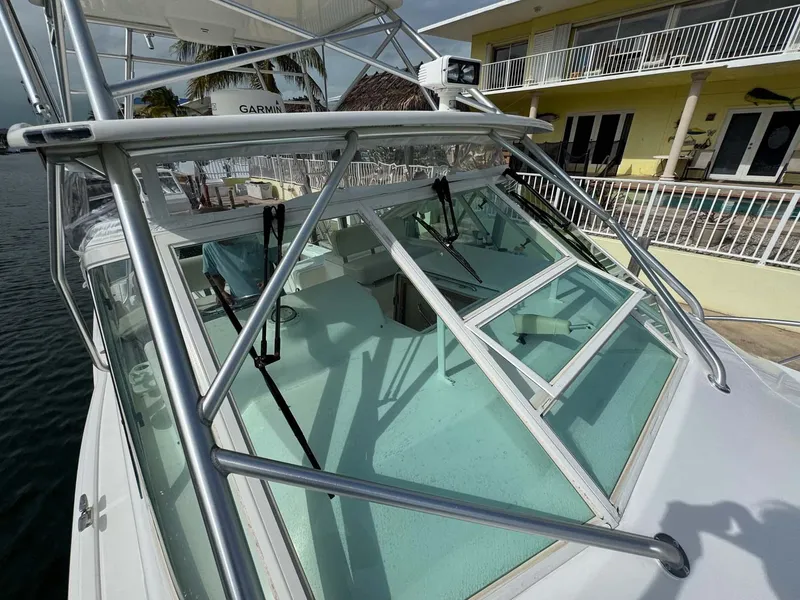 Slide: The Image of 2007 Cabo 35 Express boat with sleek design docked near a yellow building. - 29