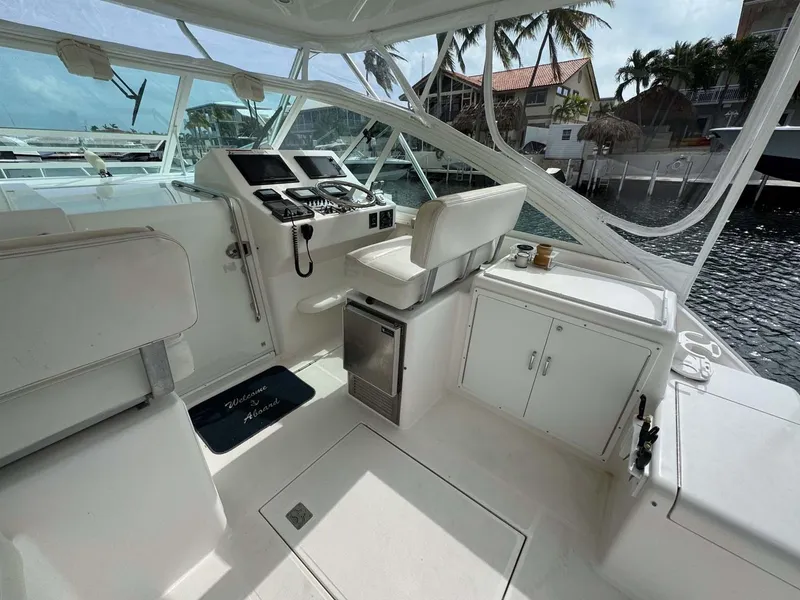 Slide: The Image of 2007 Cabo 35 Express boat interior with helm, seating, and waterfront view. - 46