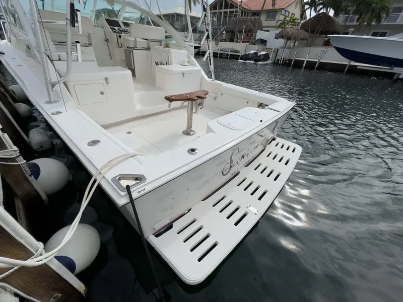 Slide: The Image of 2007 Cabo 35 Express boat docked, featuring spacious deck and swim platform. - 8