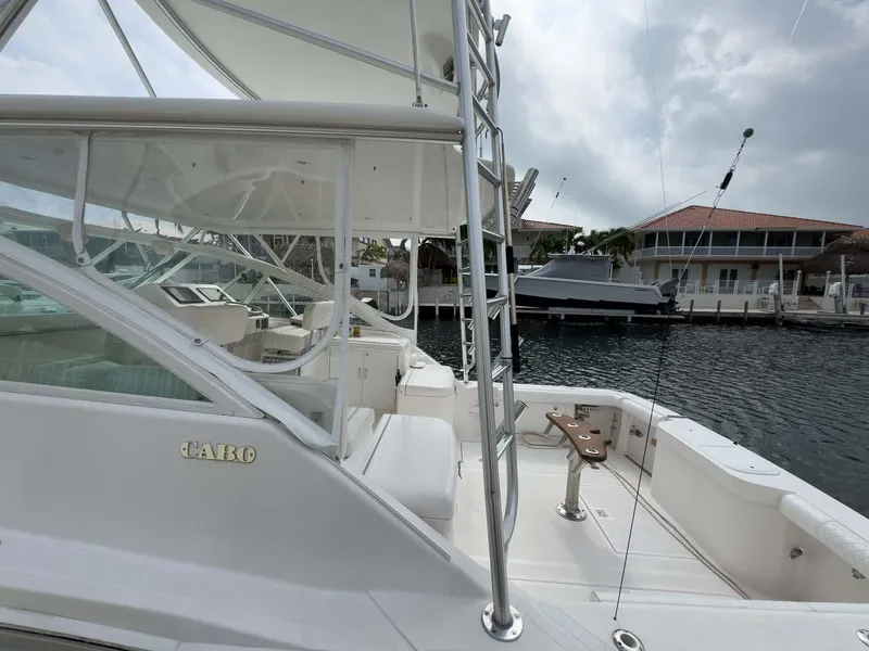 Slide: The Image of 2007 Cabo 35 Express boat docked at marina, featuring spacious deck and fishing equipment. - 9
