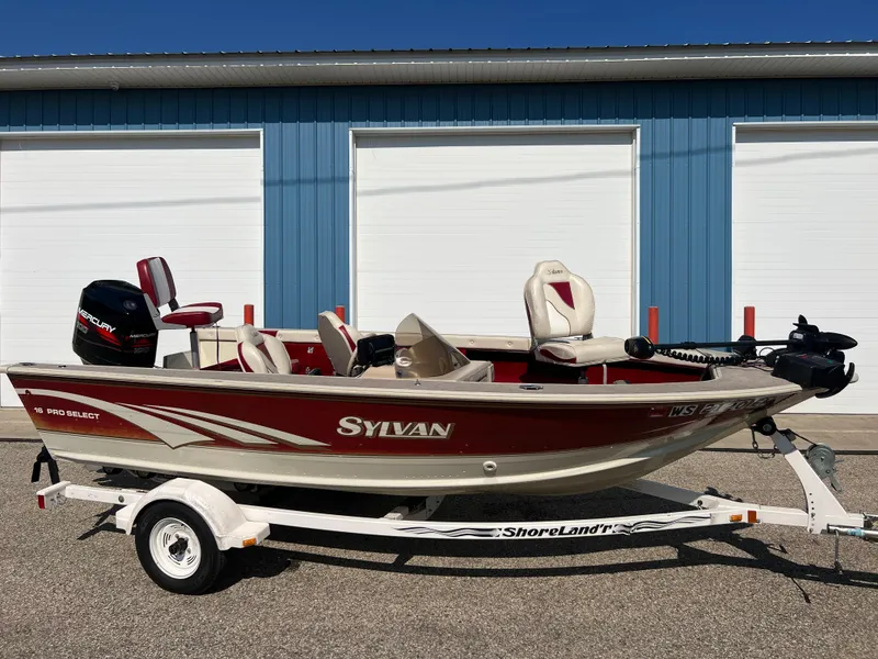 Slide: The Image of 1997 Sylvan 1600 Pro Select boat on trailer, parked in front of blue garage doors. - 1