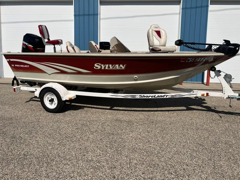 Slide: The Image of 1997 Sylvan 1600 Pro Select fishing boat on ShoreLand'r trailer, red and white design. - 2