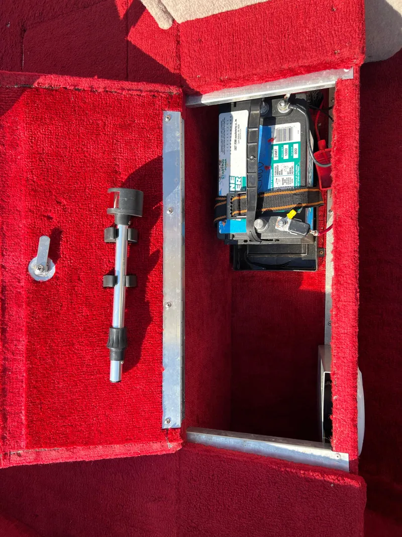 Slide: The Image of 1997 Sylvan 1600 Pro Select boat battery compartment with red carpet interior. - 24