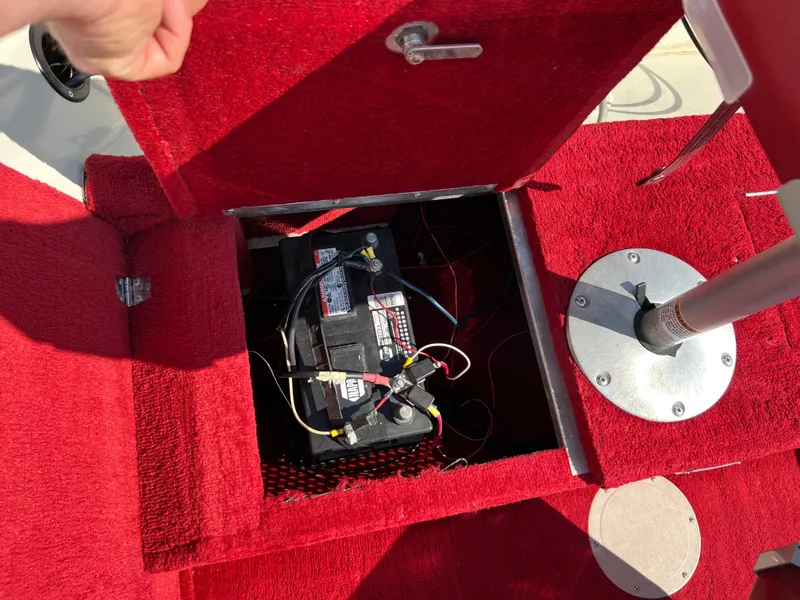 Slide: The Image of Battery compartment of a 1997 Sylvan 1600 Pro Select boat with red carpet interior. - 32