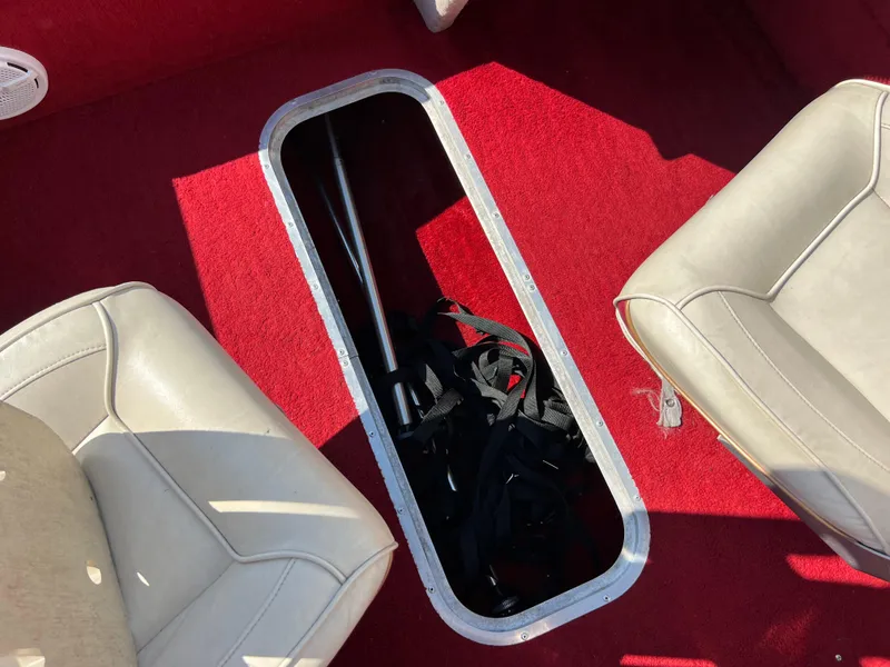 Slide: The Image of 1997 Sylvan 1600 Pro Select boat interior with red carpet and storage compartment. - 34
