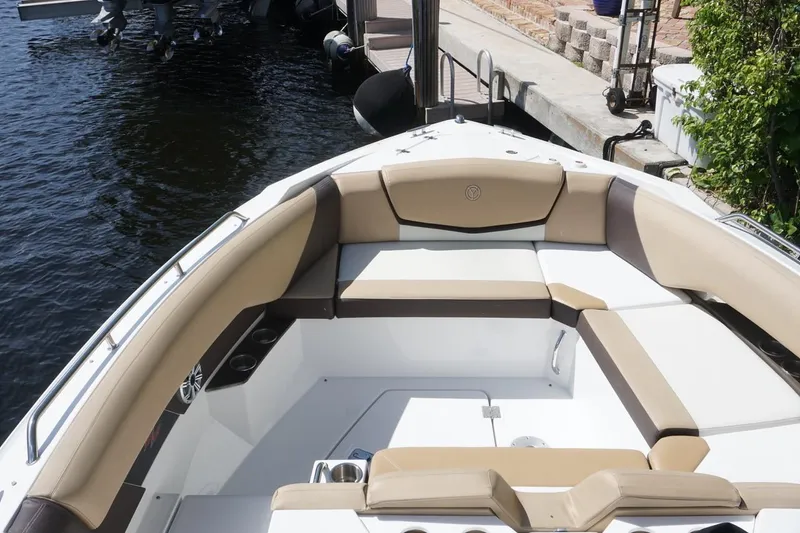 Slide: The Image of 2015 Cruisers Yachts 328 BR boat interior with beige seating, docked by the water. - 3