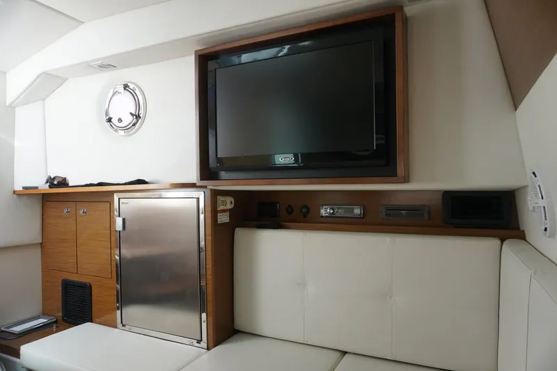 Slide: The Image of Interior of 2015 Cruisers Yachts 328 BR with TV, fridge, and seating. - 5