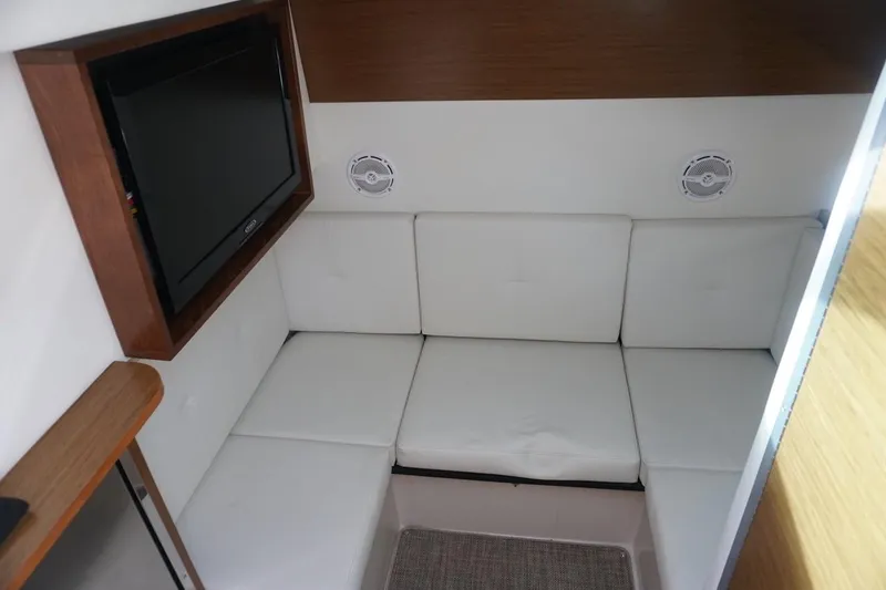 Slide: The Image of 2015 Cruisers Yachts 328 BR interior with white seating and wall-mounted TV. - 6