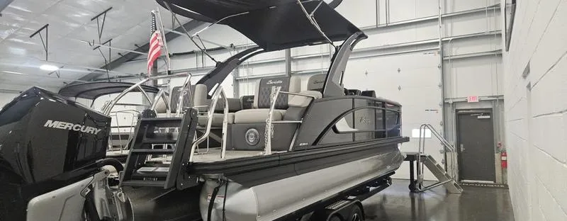 Slide: The Image of 2025 Barletta L23MA pontoon boat with Mercury engine in indoor showroom. - 5