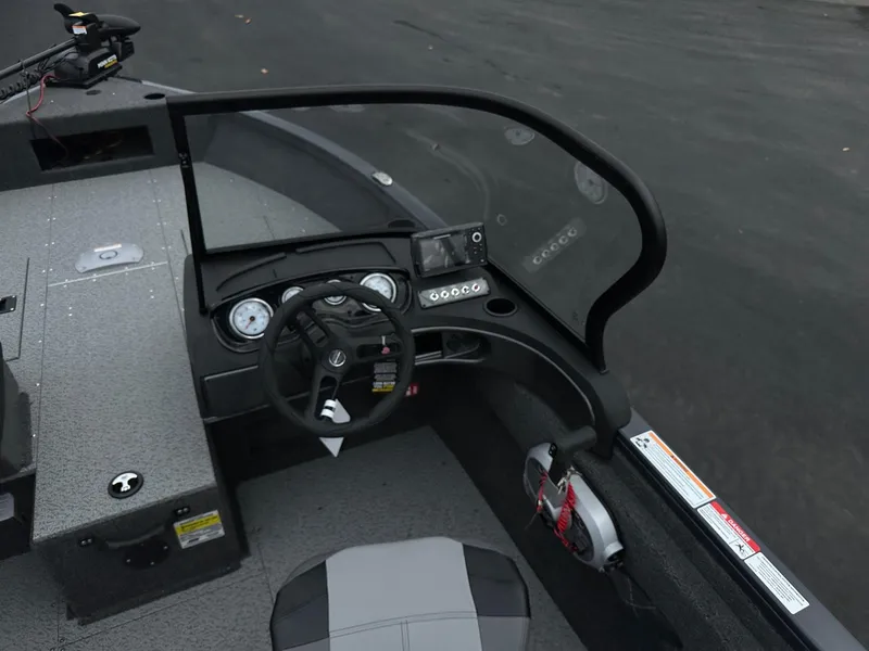 Slide: The Image of 2025 Crestliner 1650 Hawk WT boat interior with steering wheel and dashboard controls. - 2