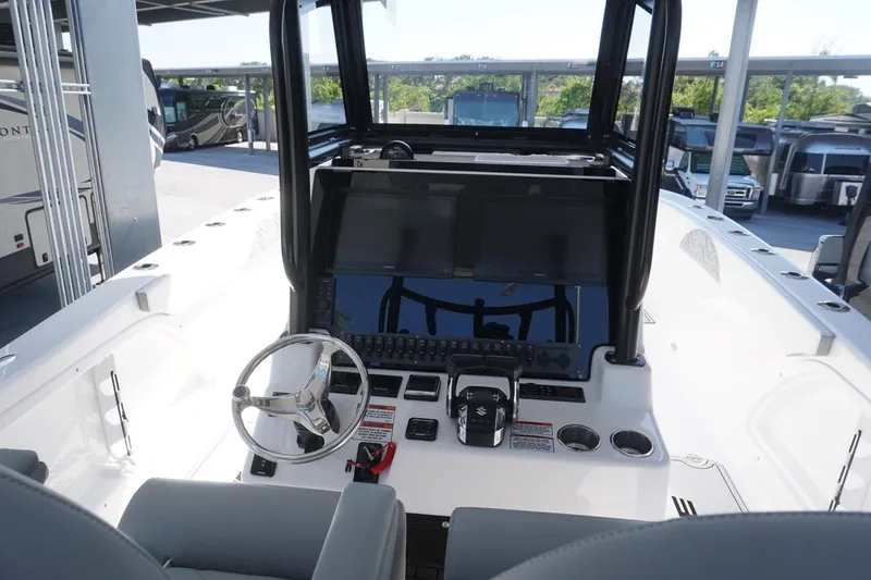 Slide: The Image of 2023 Twin Vee 280 GFX CC boat cockpit with steering wheel and control panel. - 11