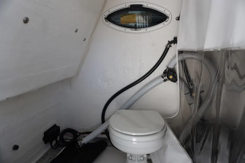 Slide: The Image of 2023 Twin Vee 280 GFX CC boat interior with marine toilet and porthole. - 15
