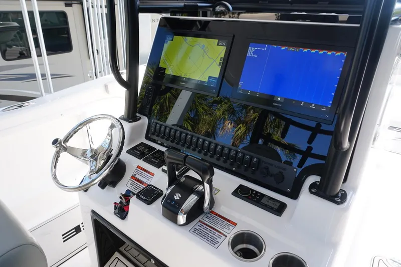 Slide: The Image of 2023 Twin Vee 280 GFX CC boat dashboard with dual screens and steering wheel. - 19