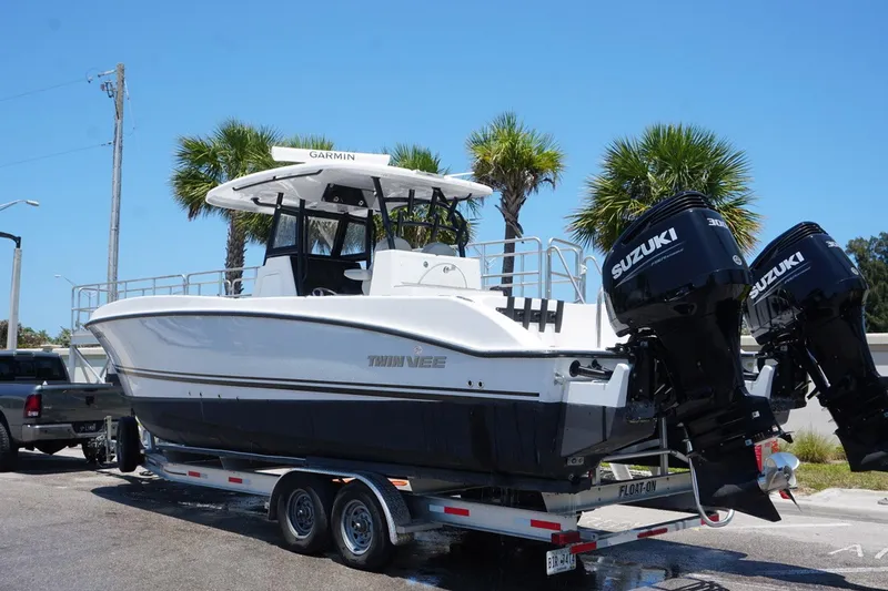 Slide: The Image of 2023 Twin Vee 280 GFX CC boat on trailer with Suzuki engines. - 2